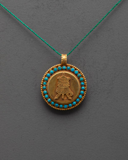 Close-up of intricate parasol design on gold-plated copper locket with stone accents