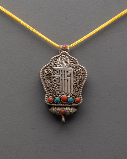 Close-up of intricate silver filigree and Kalachakra mantra engraving on Tibetan Ghau locket
