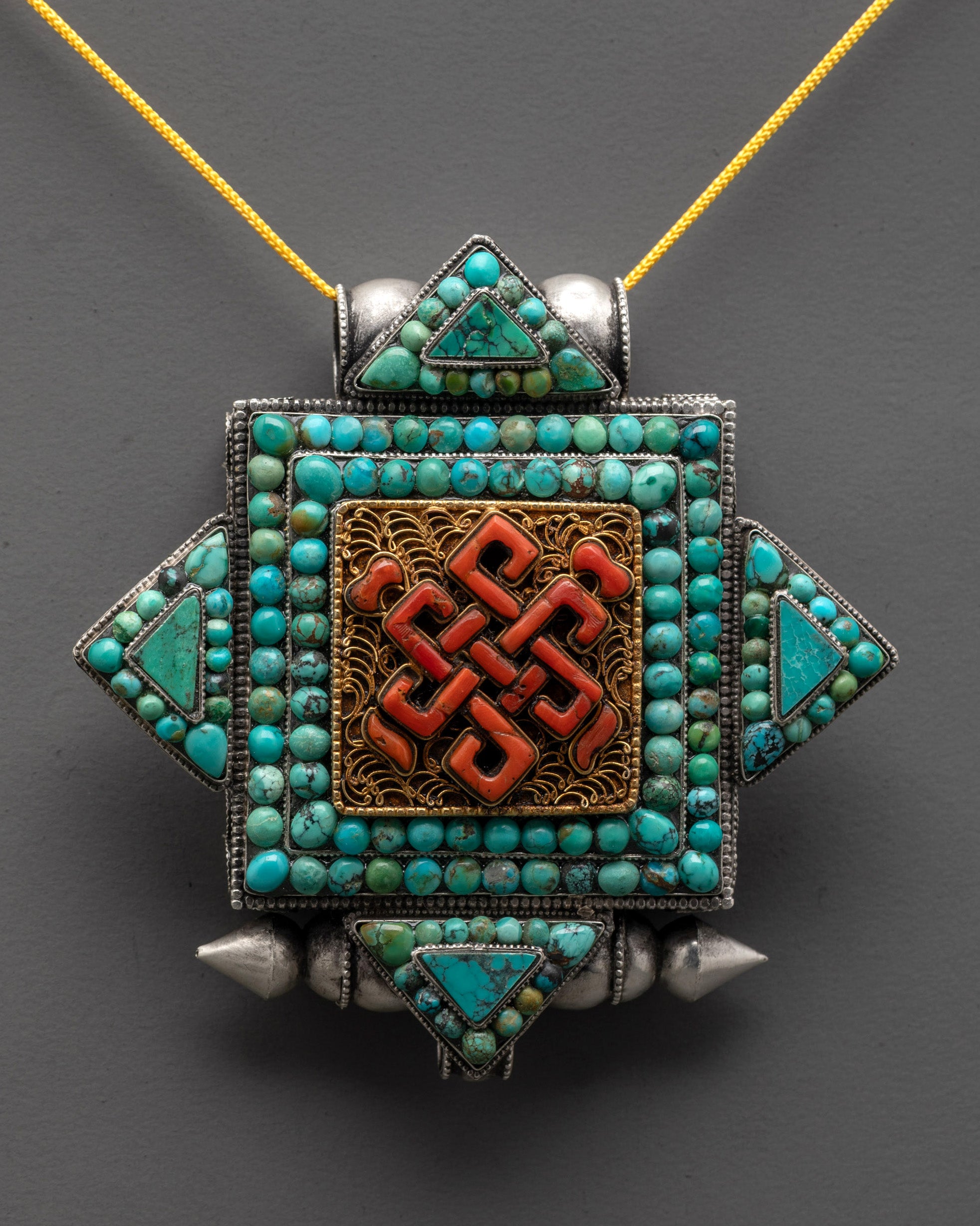 Close up of silver Endless Knot Locket showing intricate gold-plated filigree and stone details