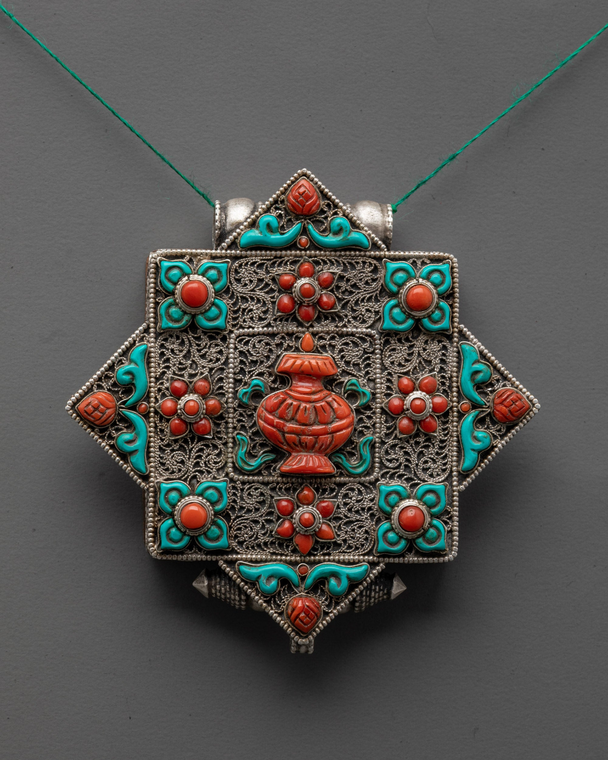 close up of intricate carving on Tibetan Treasure Vase locket showcasing detailed craftsmanship
