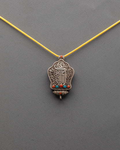 Front view of Kalachakra Mantra Amulet Pendant with silver filigree and turquoise, coral stones
