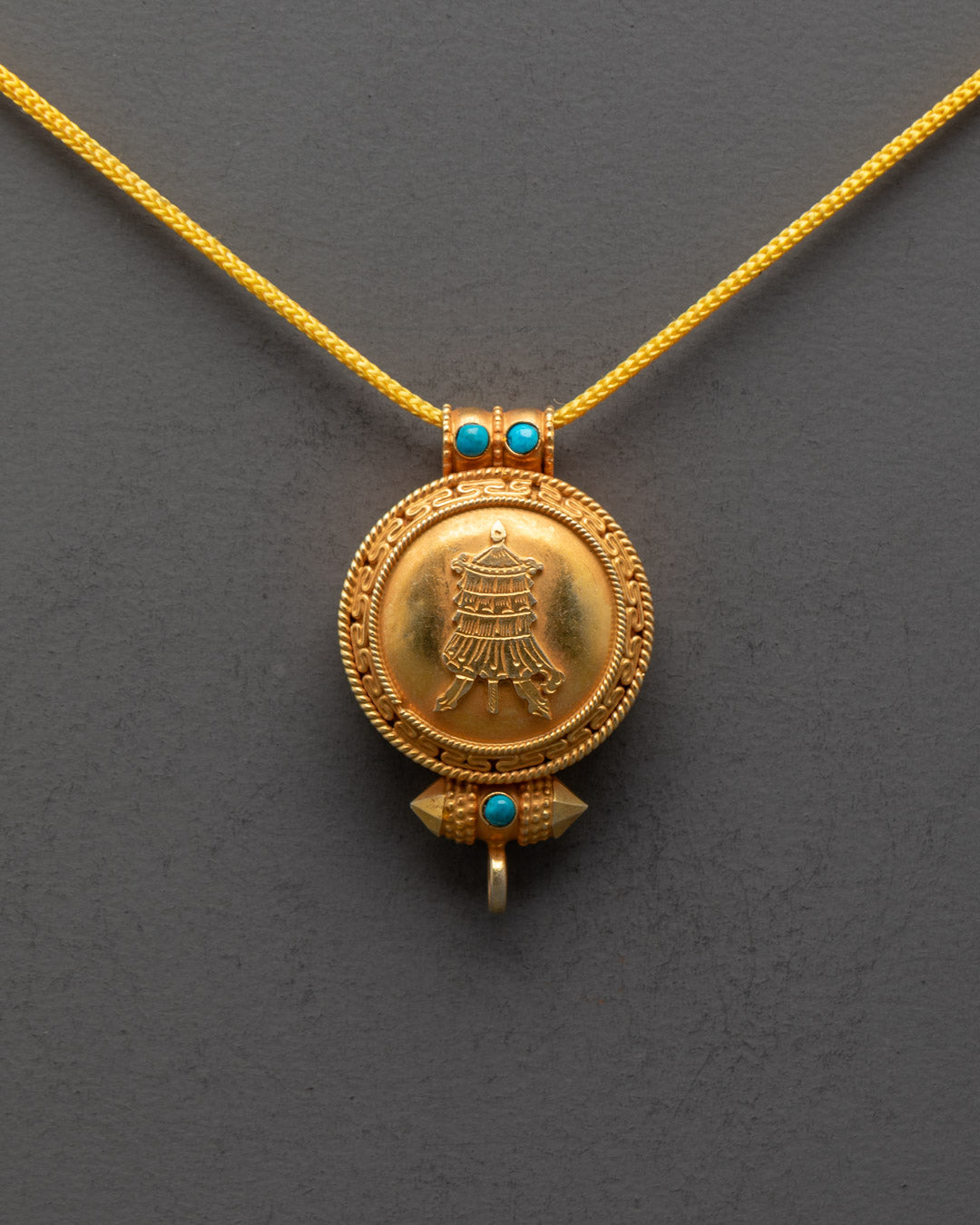 Front view of Gyeltshen Banner Locket with gold-gilded body and semi-precious stones