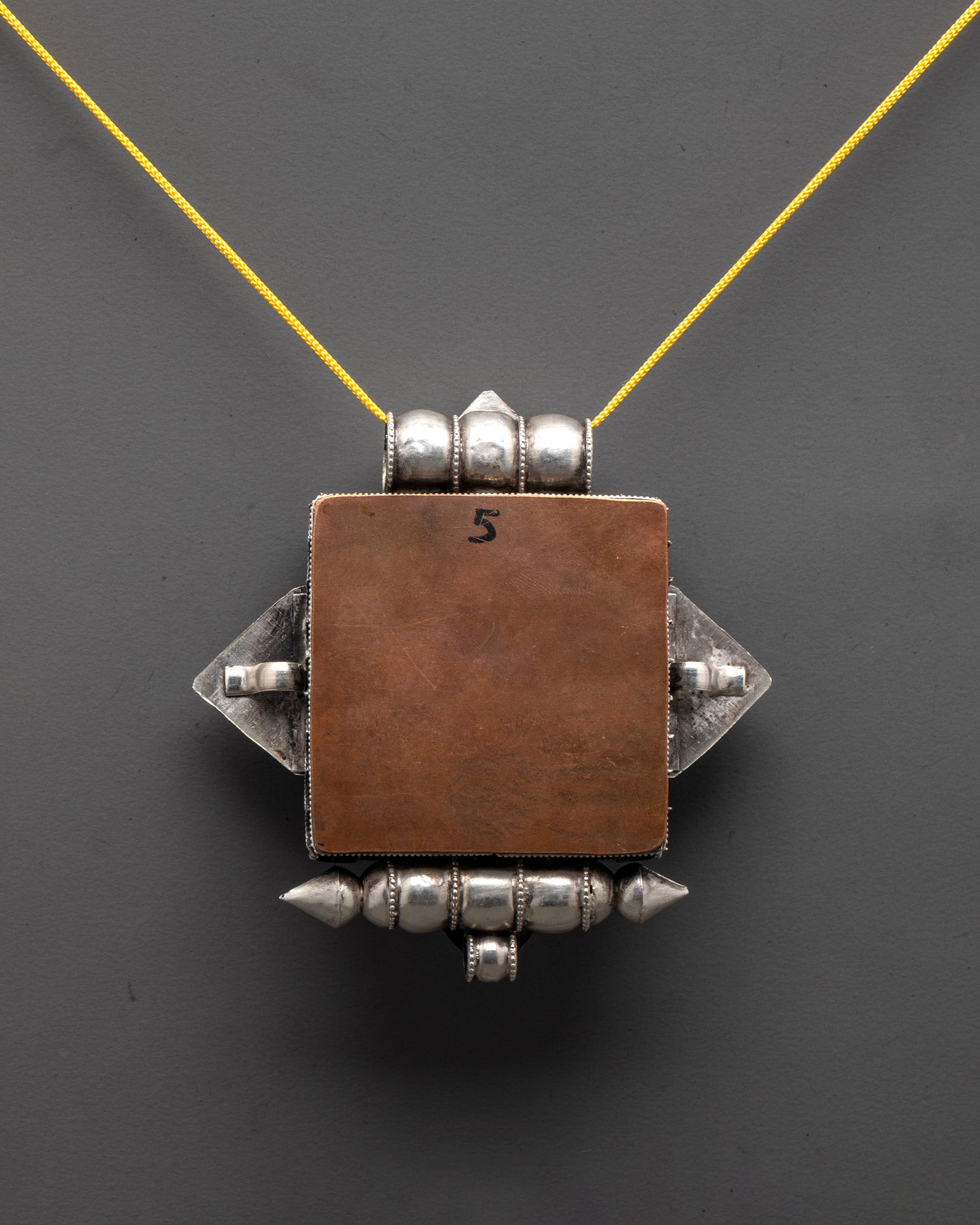 Back view of silver Endless Knot Locket highlighting detailed carving and fine craftsmanship