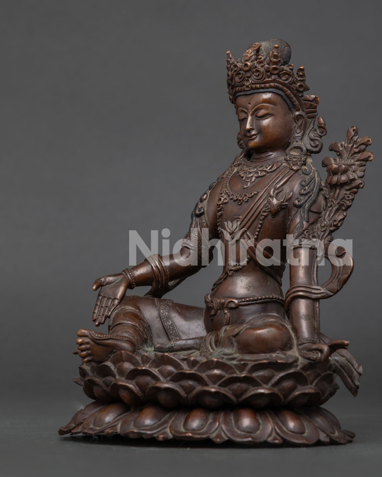 Lokeshwor statue holding flowering lotus stem with oxidized copper finish.