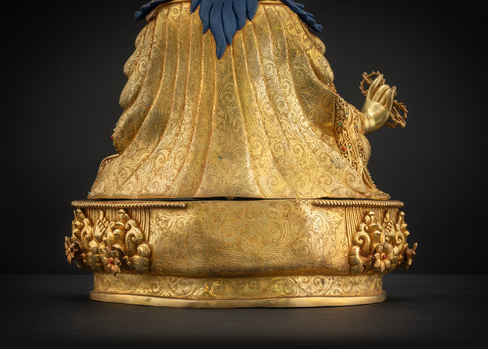 Lower back landscape view showing carved pedestal and layered attire