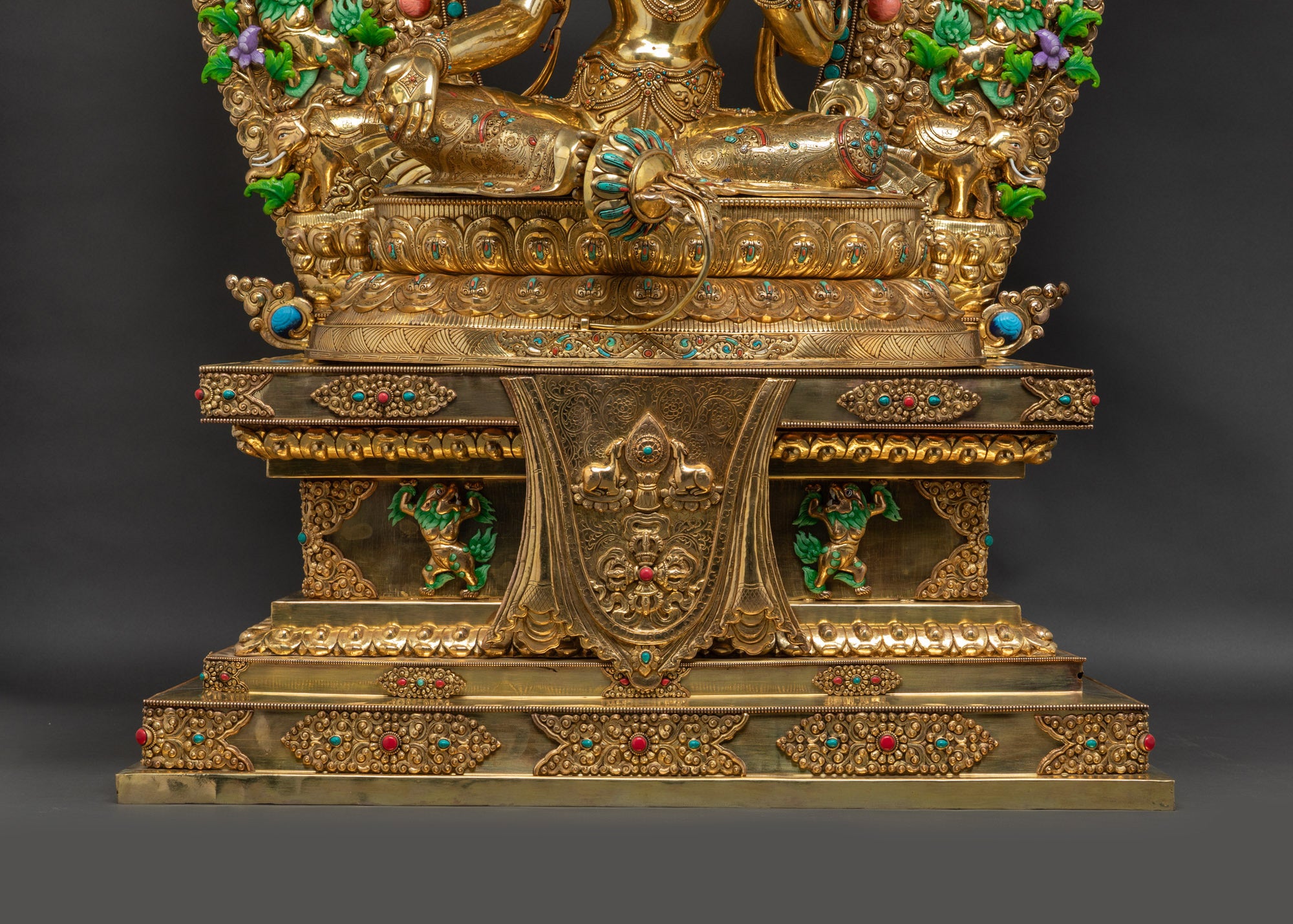Lower landscape shot front of Green Tara Statue on lotus seat with Tibetan throne
