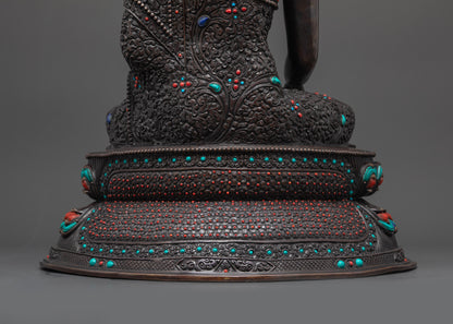 Lower landscape shot of statue seated on lotus seat back Buddha Shakyamuni oxidized
