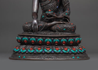 Lower landscape shot of statue seated on lotus seat front Buddha Shakyamuni oxidized
