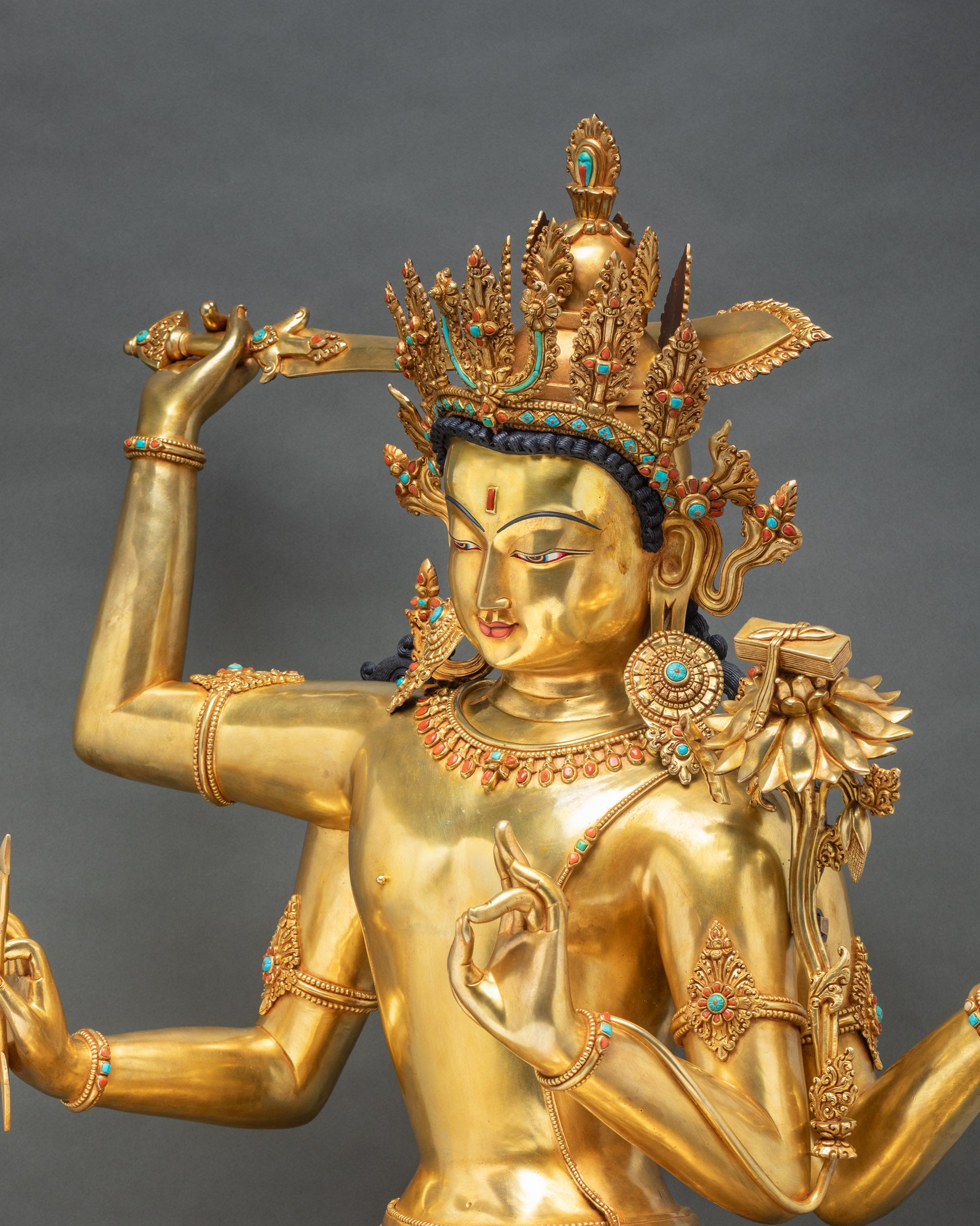 Maha Manjushri statue right profile showing intricate gold fire-gilding, semi-precious stones, ornate jewelry, and arm details