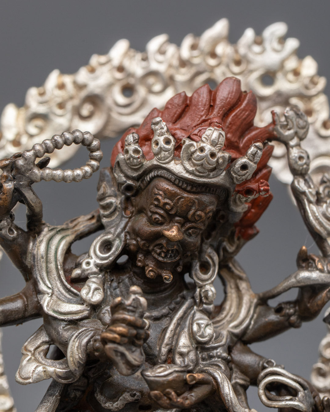 Mahakala’s five-skull crown, intricate jewelry, and detailed floating robe on silver-plated sculpture
