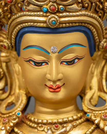 Detailed close-up of Manjushree Sculpture serene face with full crown and gold-gilded halo