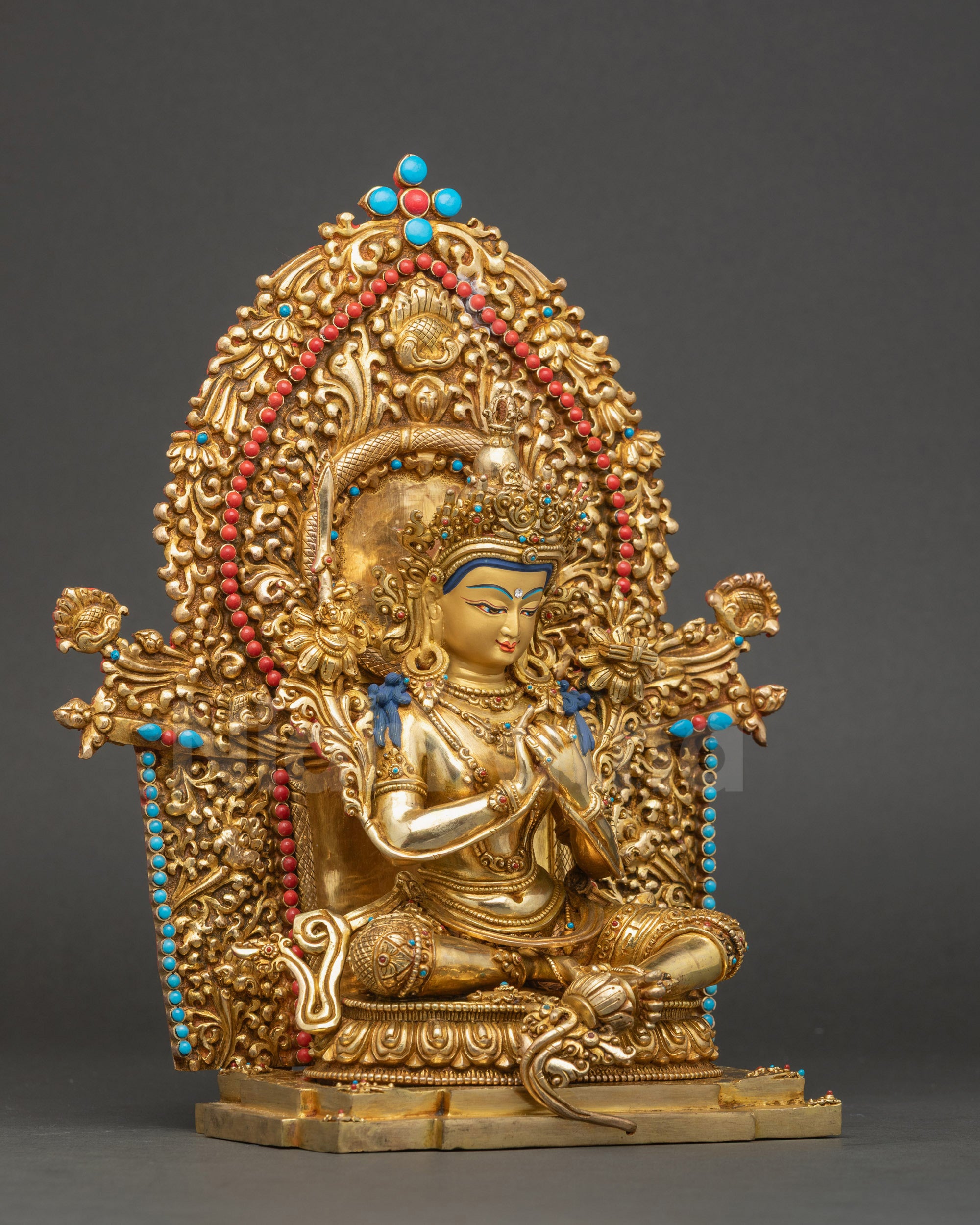 Right side of Manjushree Sculpture showing dharmachakra mudra, flowing robe, and semi-precious stones