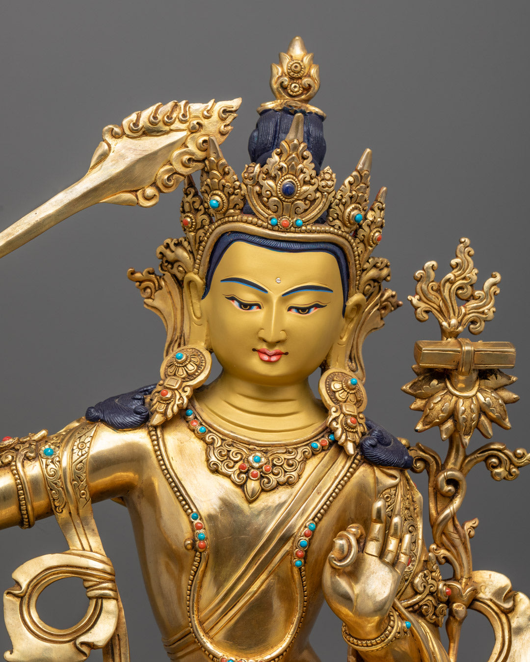 Manjushri statue’s serene face and crown, highlighting 24K gold gilding and delicate hand-carved features