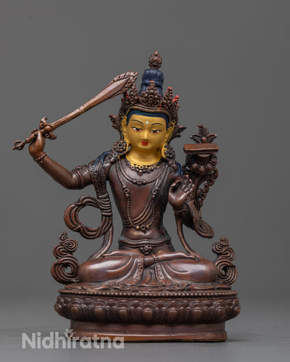 front view of machine-crafted manjushri statue with gold face and oxidized copper body