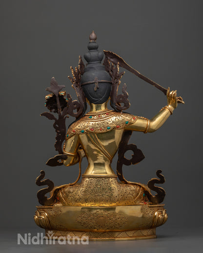 Manjushri Buddha statue, focusing on the fine craftsmanship of the gold-glided copper work, the rich detailing on the garments, and the meticulous artistry that reflects over a month of dedicated, masterful creation.