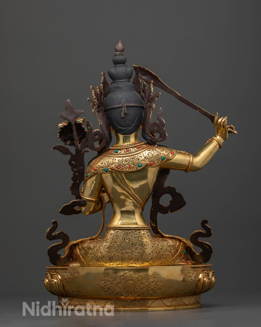 Manjushri Buddha statue, focusing on the fine craftsmanship of the gold-glided copper work, the rich detailing on the garments, and the meticulous artistry that reflects over a month of dedicated, masterful creation.
