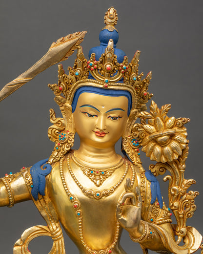 Manjushri Statue close up showing gold-gilded face and detailed lotus seatcarvings