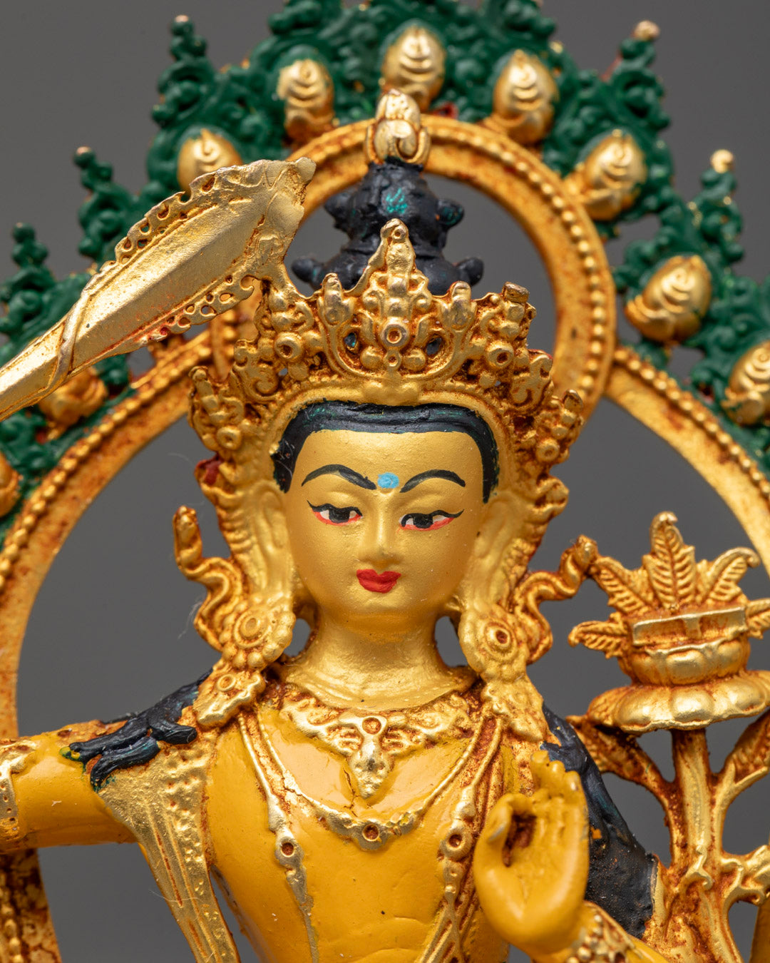 Manjushri holding flaming double-edged sword and utpala flower representing the cutting of ignorance and transcendent wisdom
