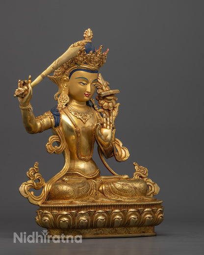 Manjushri statue holding double-edged sword with vajra handle, detailed view of the Bodhisattva of Wisdom, showcasing the sharp clarity of wisdom cutting through ignorance, with gold gilding and fine carvings