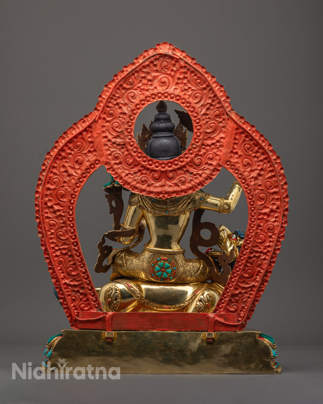 Manjushri statue radiant gold-gilded face, detailed crown, and upper body adorned with semi-precious stones and fine jewelry craftsmanship.