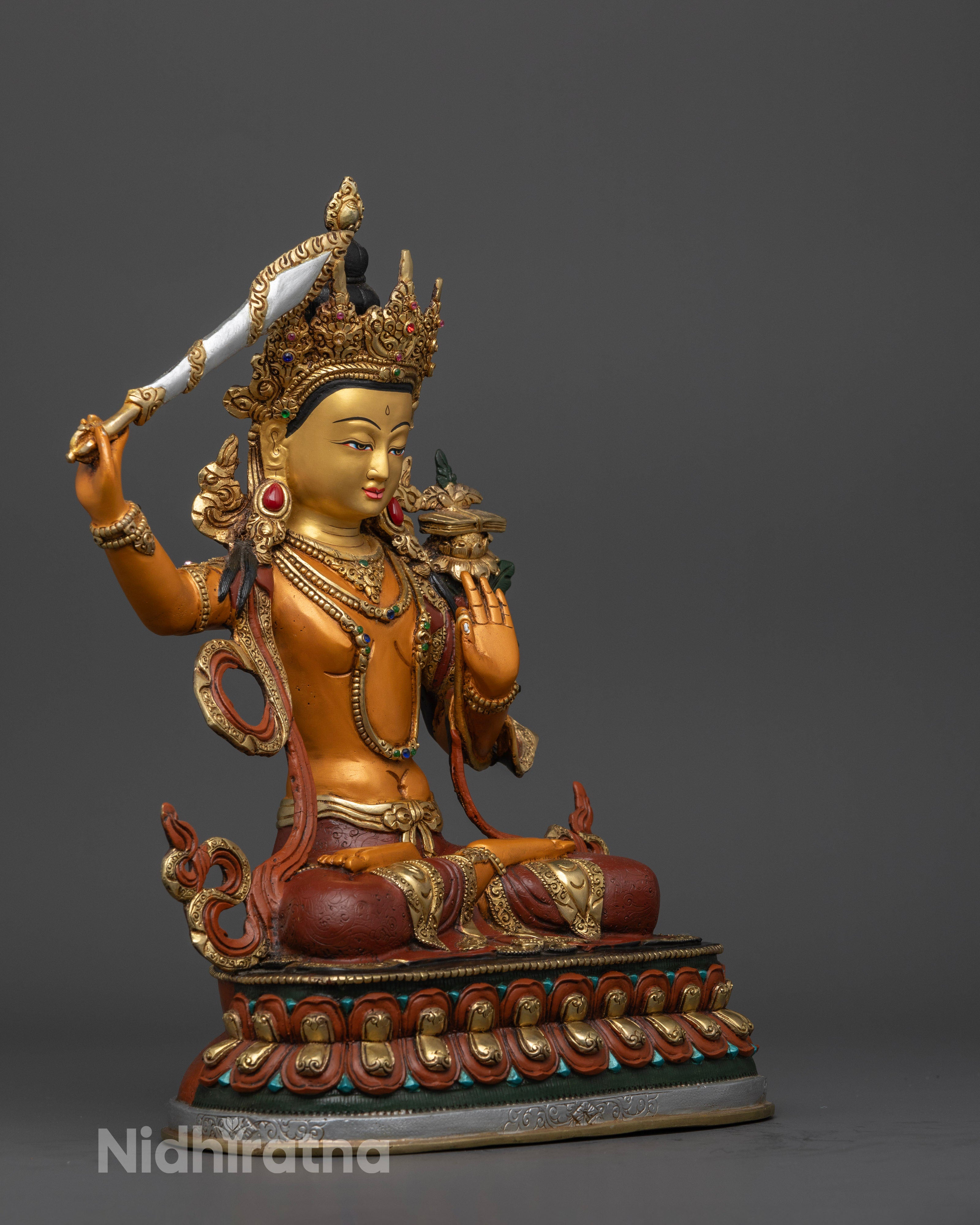 Manjushri statue, showcasing the elegant posture atop a lotus, the radiant gold finish, and the rich acrylic detailing symbolizing enlightenment and purity.