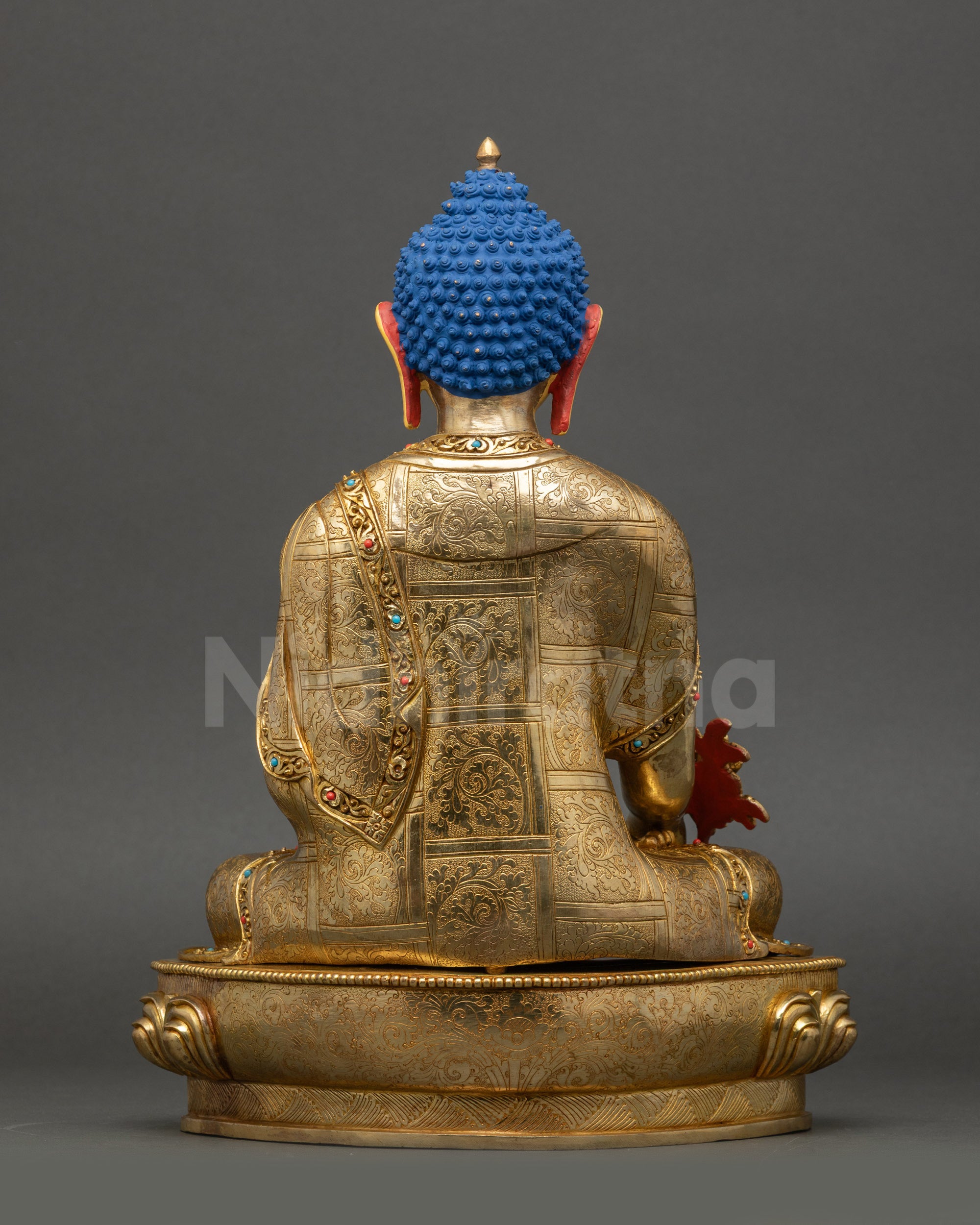 Medicine Buddha statue back view showing detailed carved garments and lotus