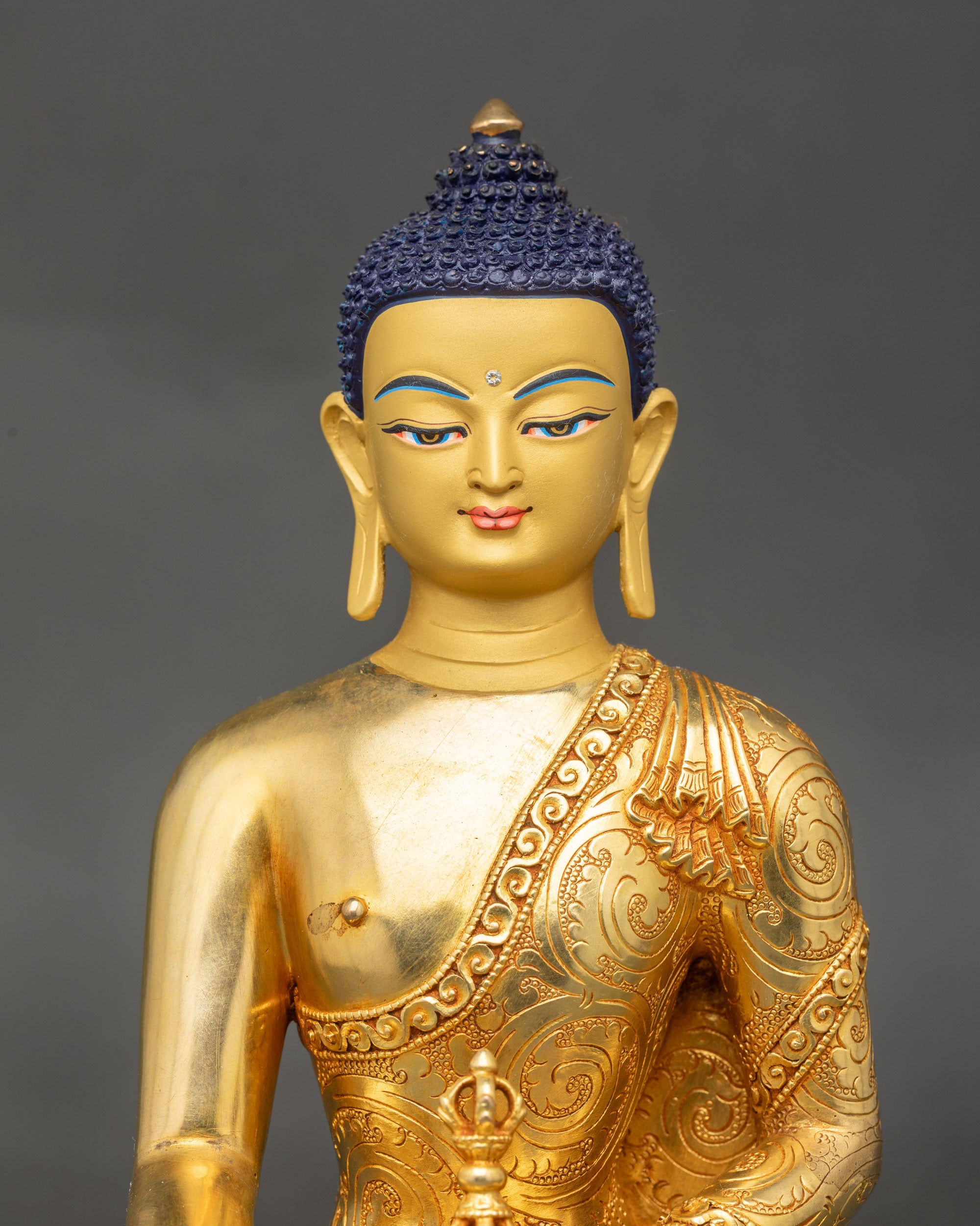 Mitrugpa Buddha statue close up showing gold-gilded body and lotus posture