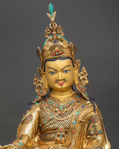 Close-up of Padmasambhava statue showing gold fire-gilding, copper texture, and lotus throne details
