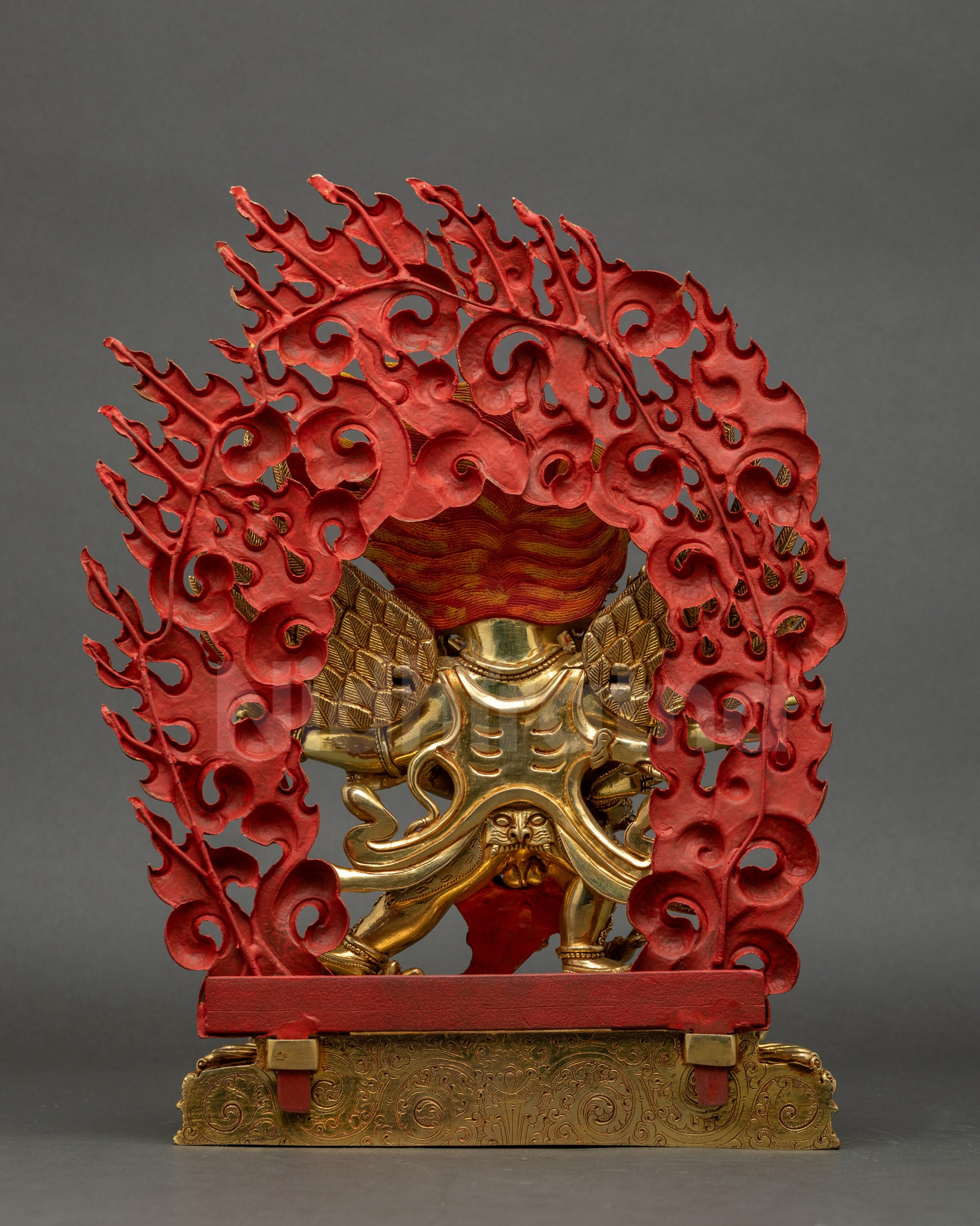 Back view of Hayagriva statue showing giant halo, detailed lower garments, and flowing robe.