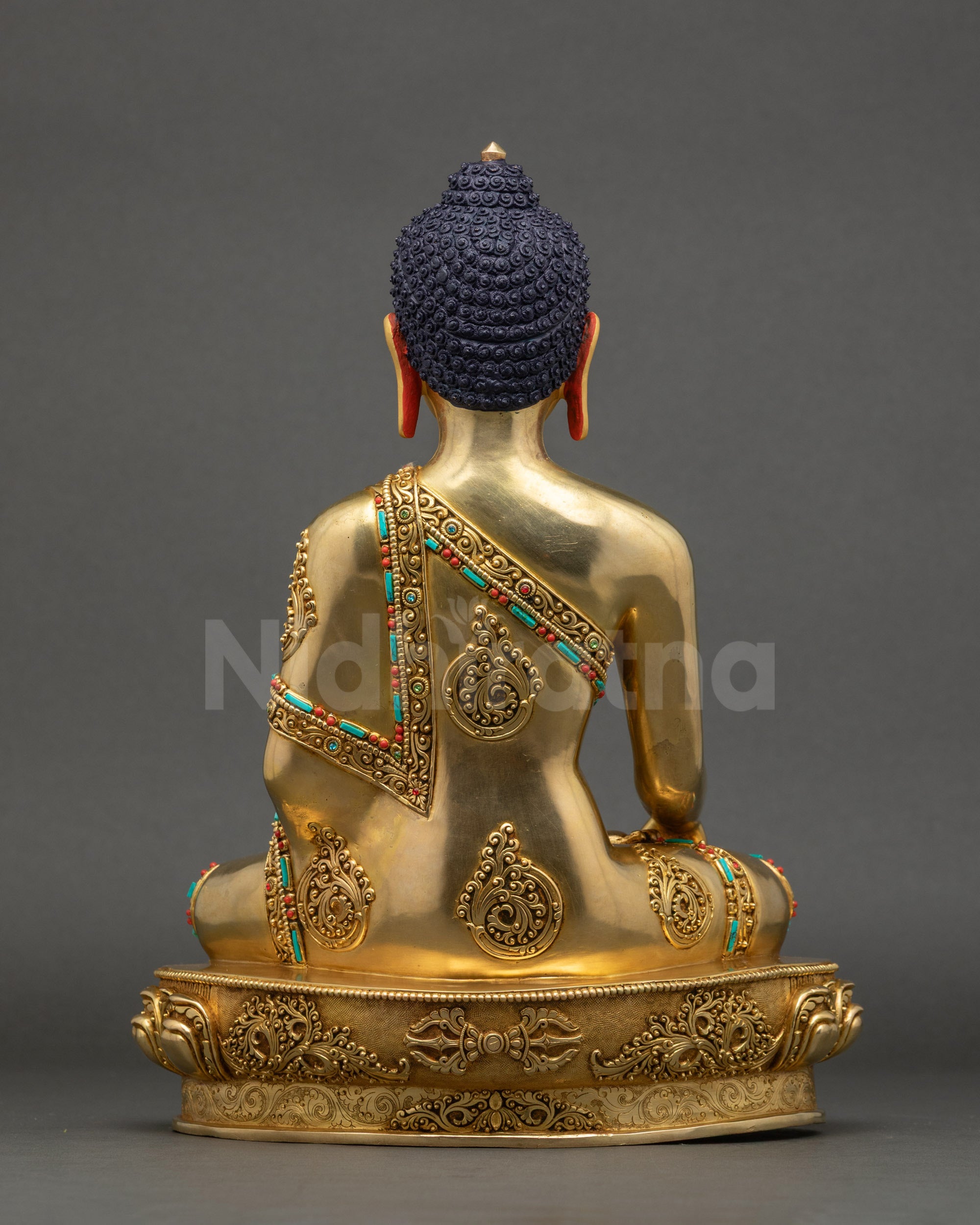 Back of Shakyamuni Buddha statue showing carved lotus pedestal and robe folds