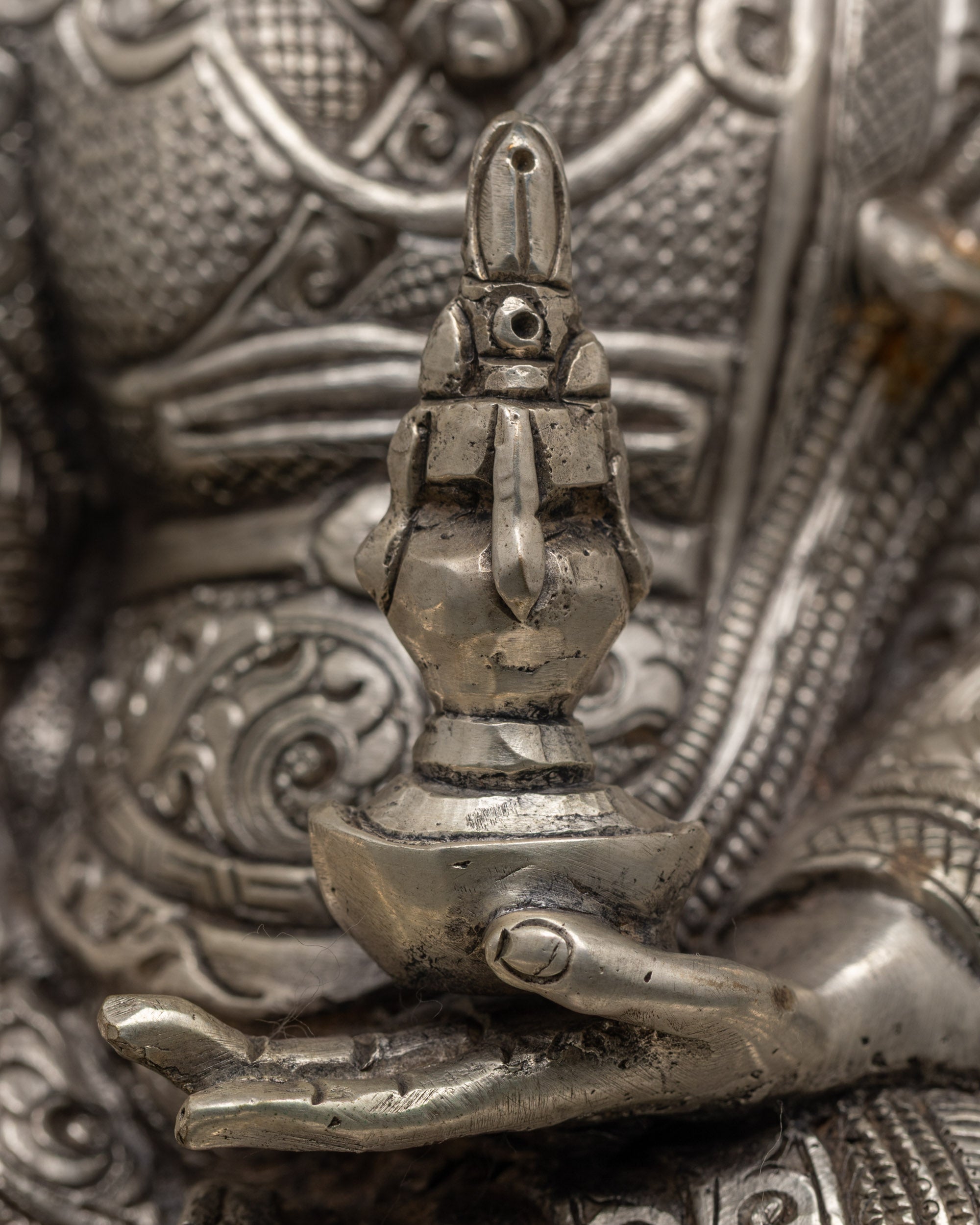 Rear view of traditional Nepalese Guru Rinpoche sculpture with ornate silver-plated robe