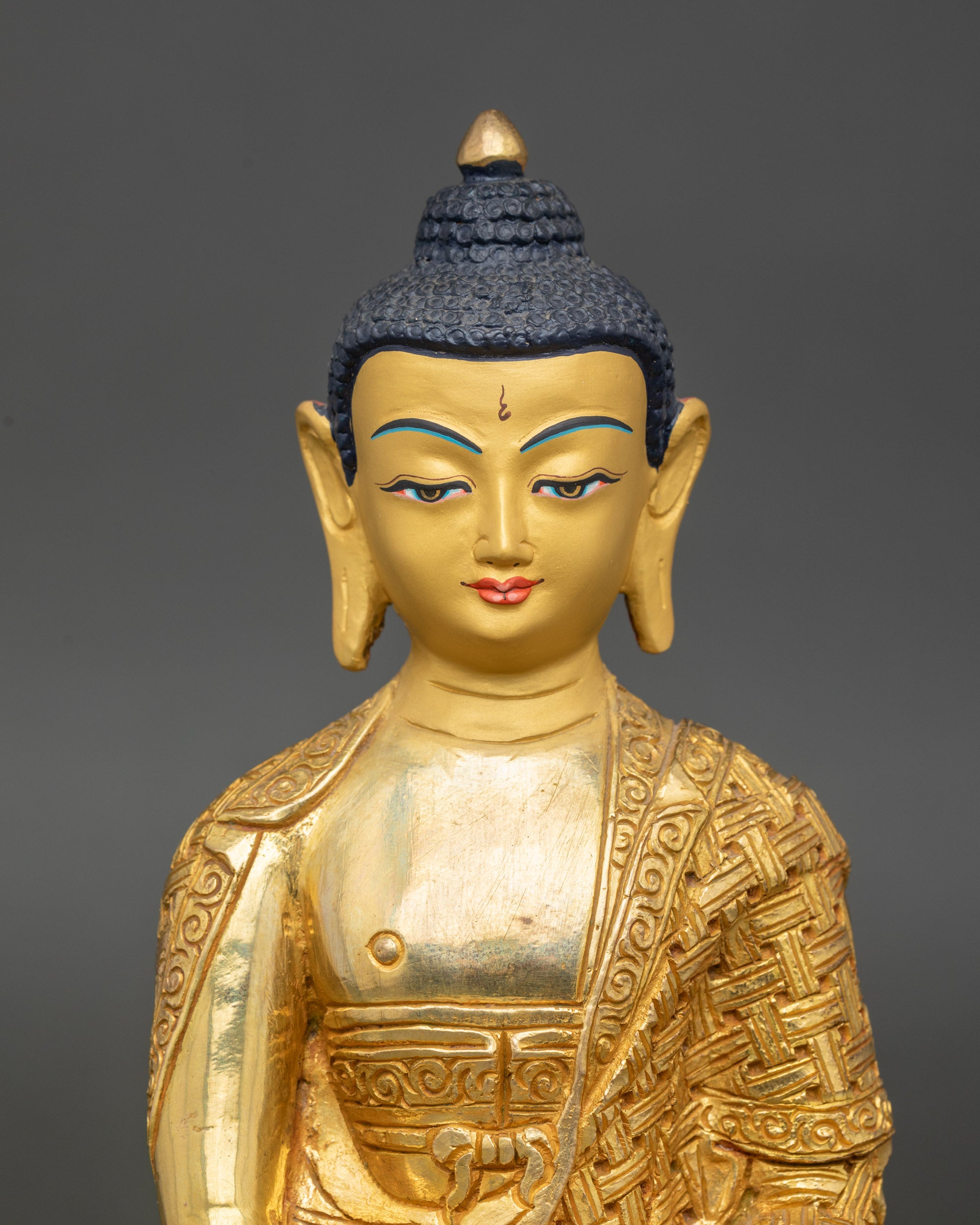 Regular close-up of Amitabha Buddha statue showing serene gold-painted face and intricate garments