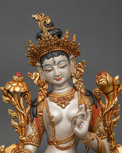 Regular close-up of White Tara Bodhisattva sculpture, painted copper, lotus seat