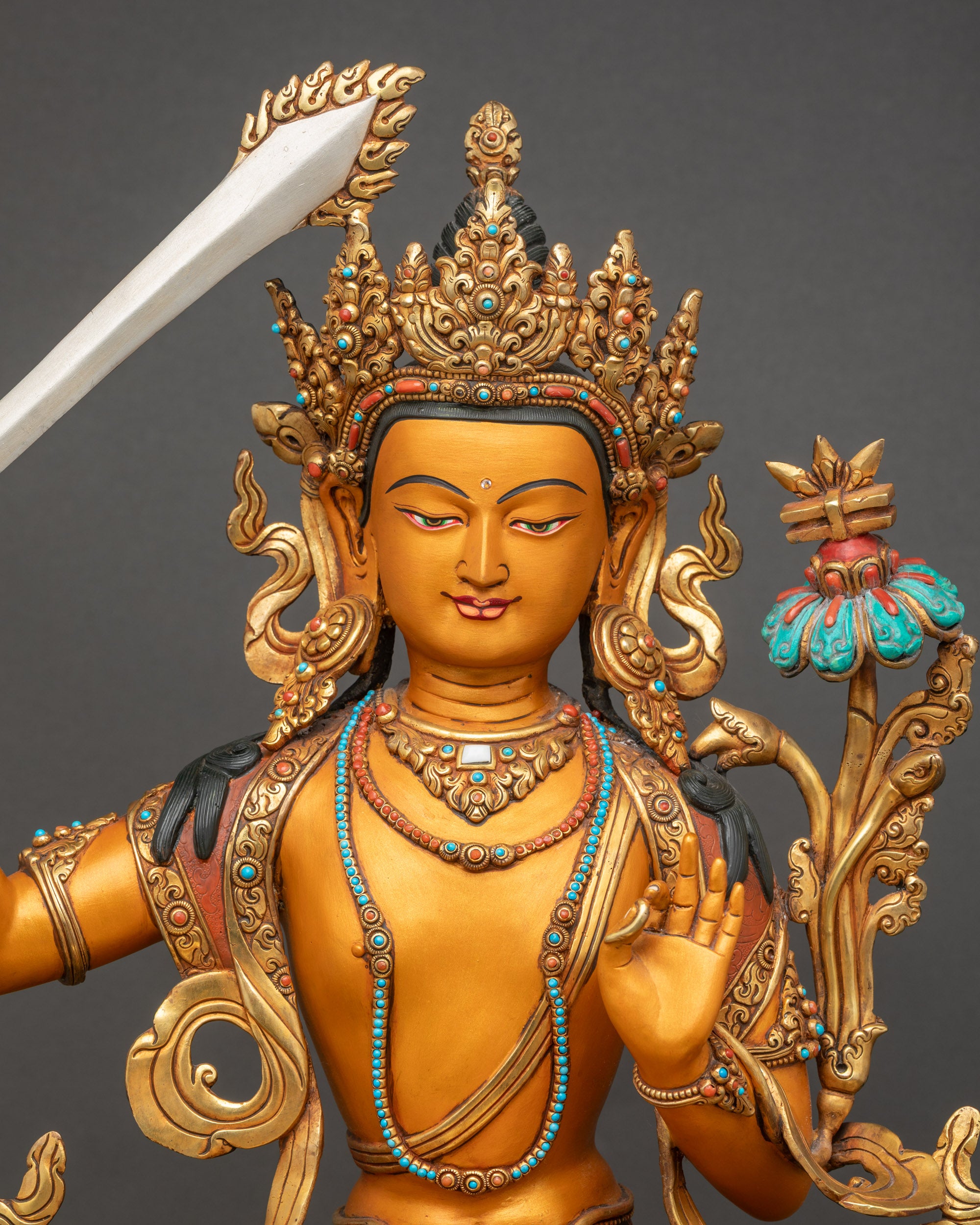 Regular close-up of vibrant Arapacana Manjushri statue with gold-plated robe and sword