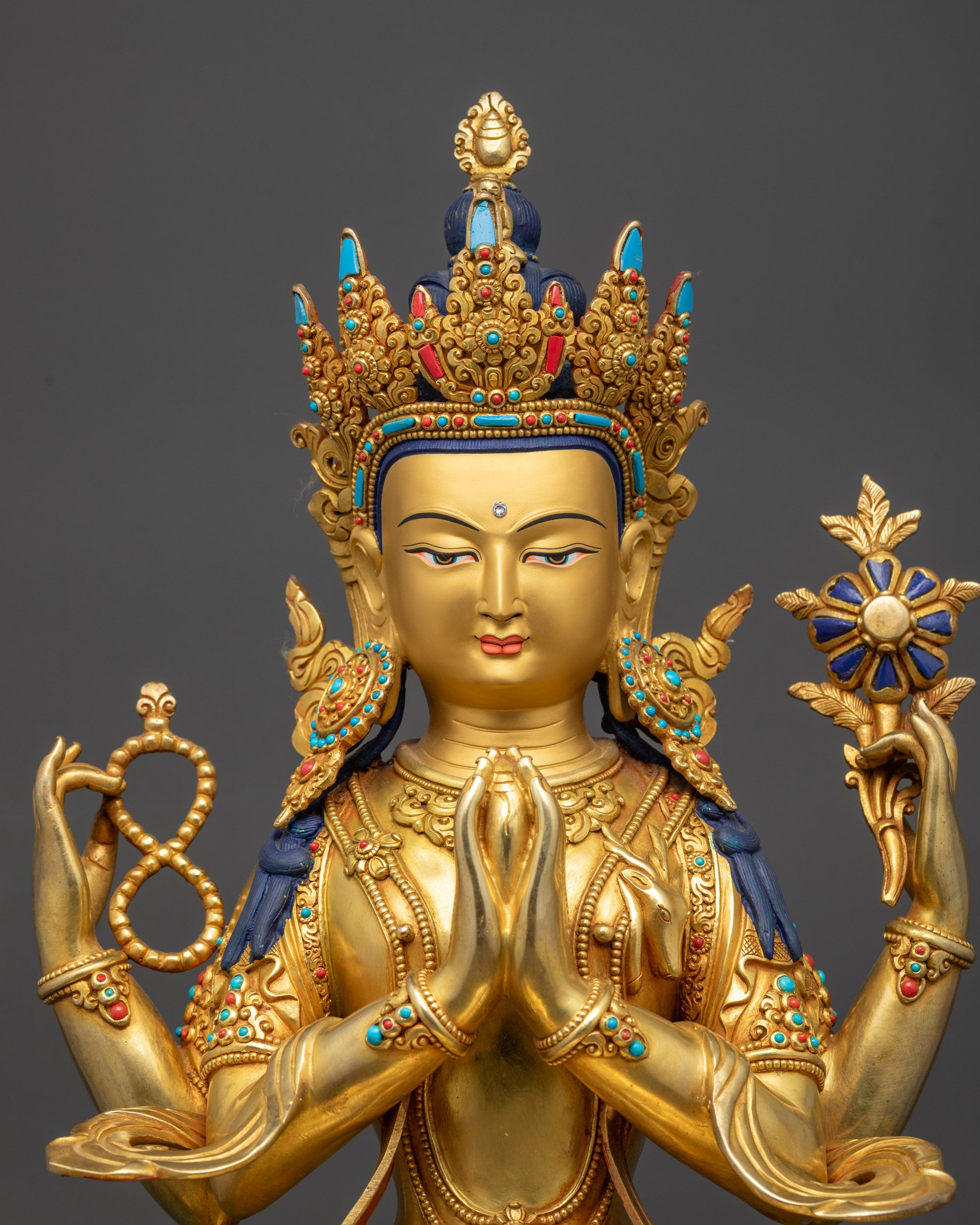 Regular close up Chenrezig Statue showing four arms and lotus flower
