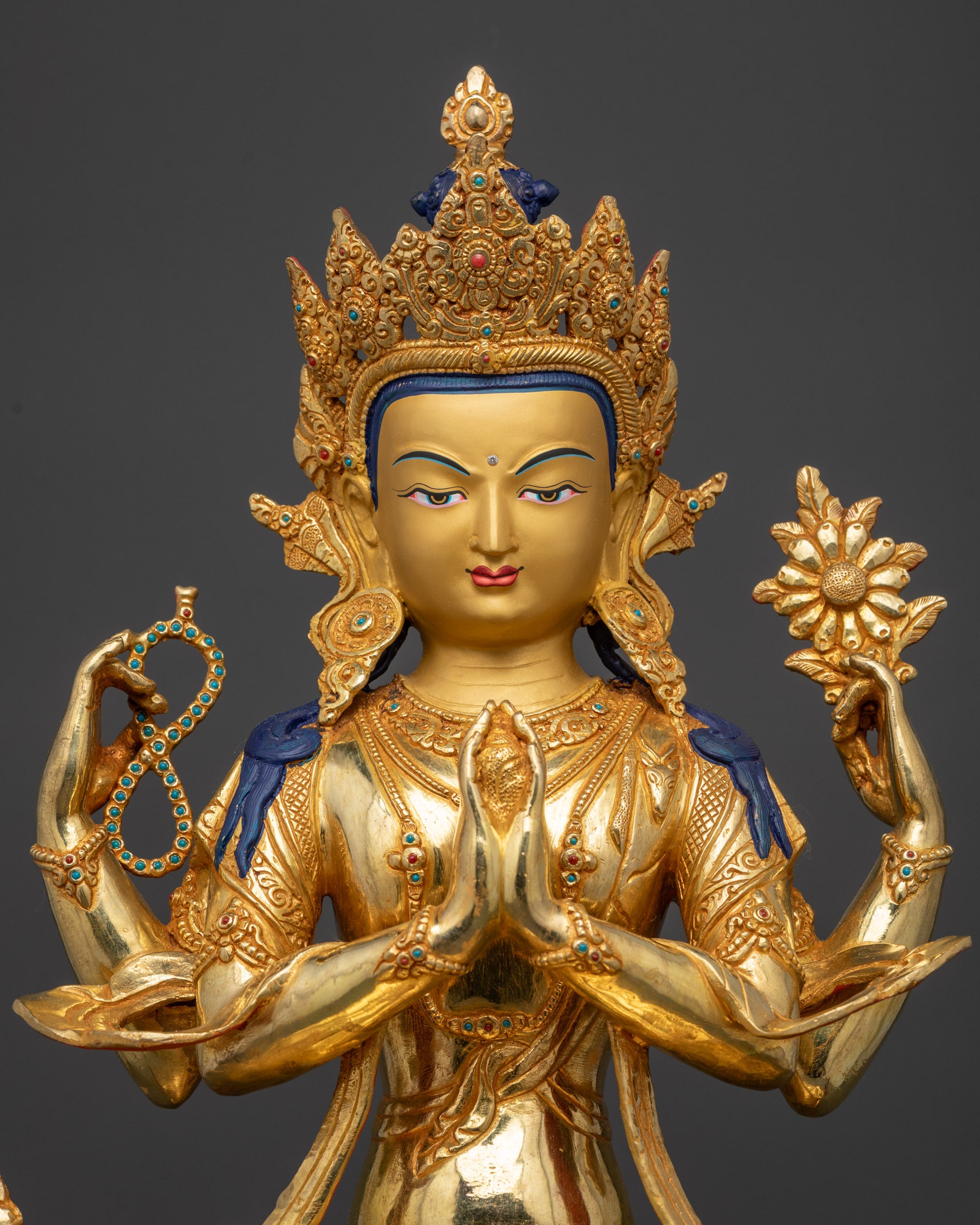 Regular close up Chenrezig sculpture showing detailed swirling robe and sacred objects