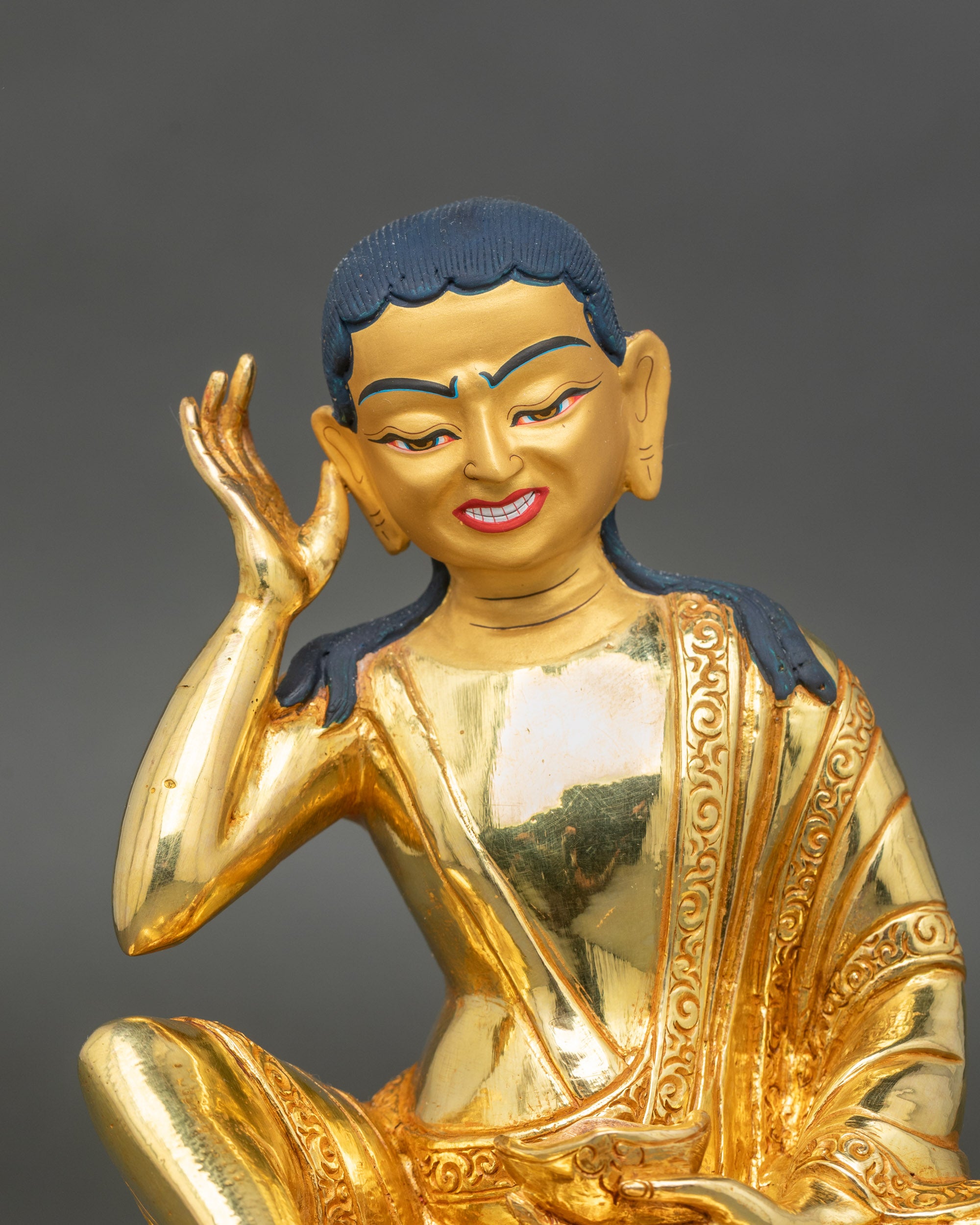 Regular close up – Close-up of Milarepa statue showing gold-painted face and detailed robes