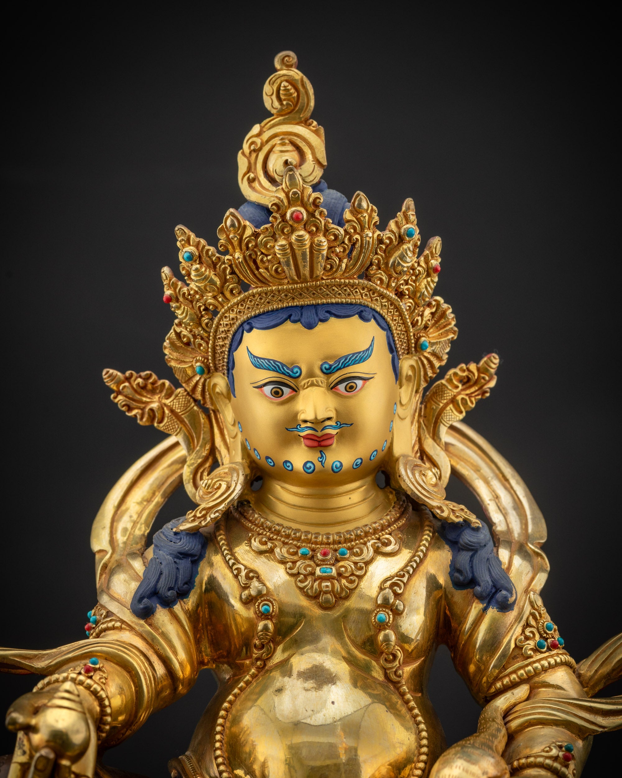 Regular close up Dzambhala gold-gilded face with mustache, beard, and intricate crown