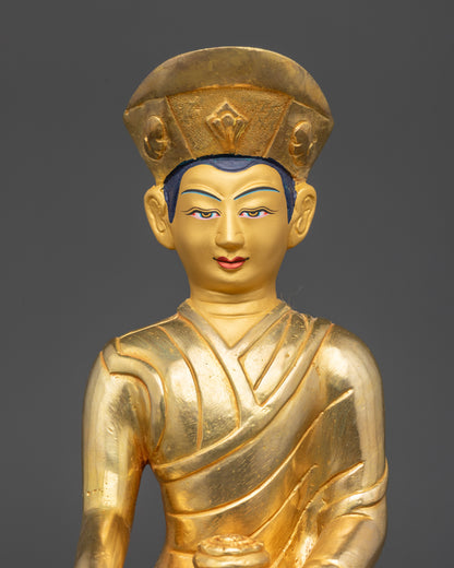 Regular close up Eighth Karmapa Jigten Sumgon statue showing tranquil gold-gilded face
