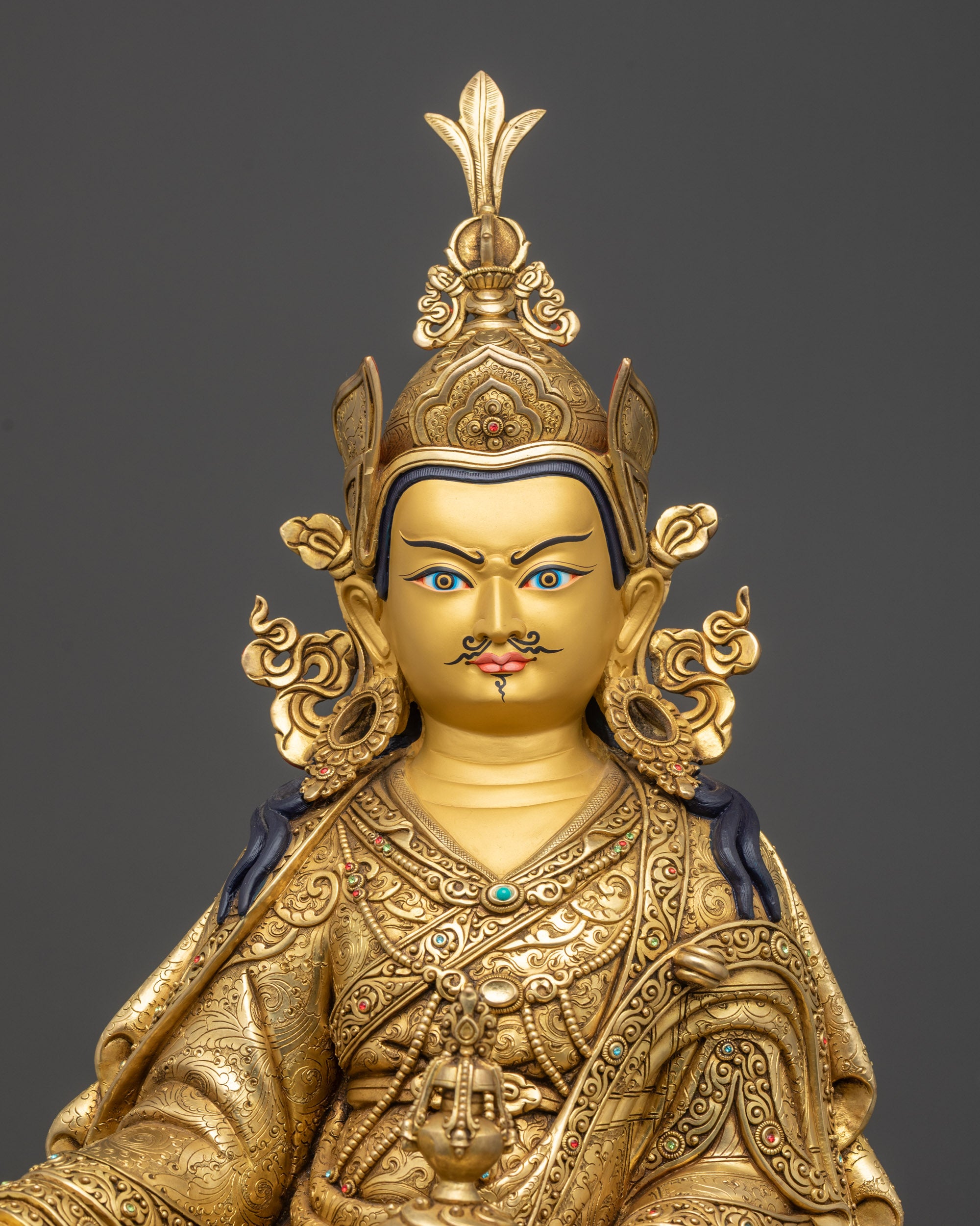 Regular close up Guru Rinpoche sculpture showing copper body and flowing kasaya robe
