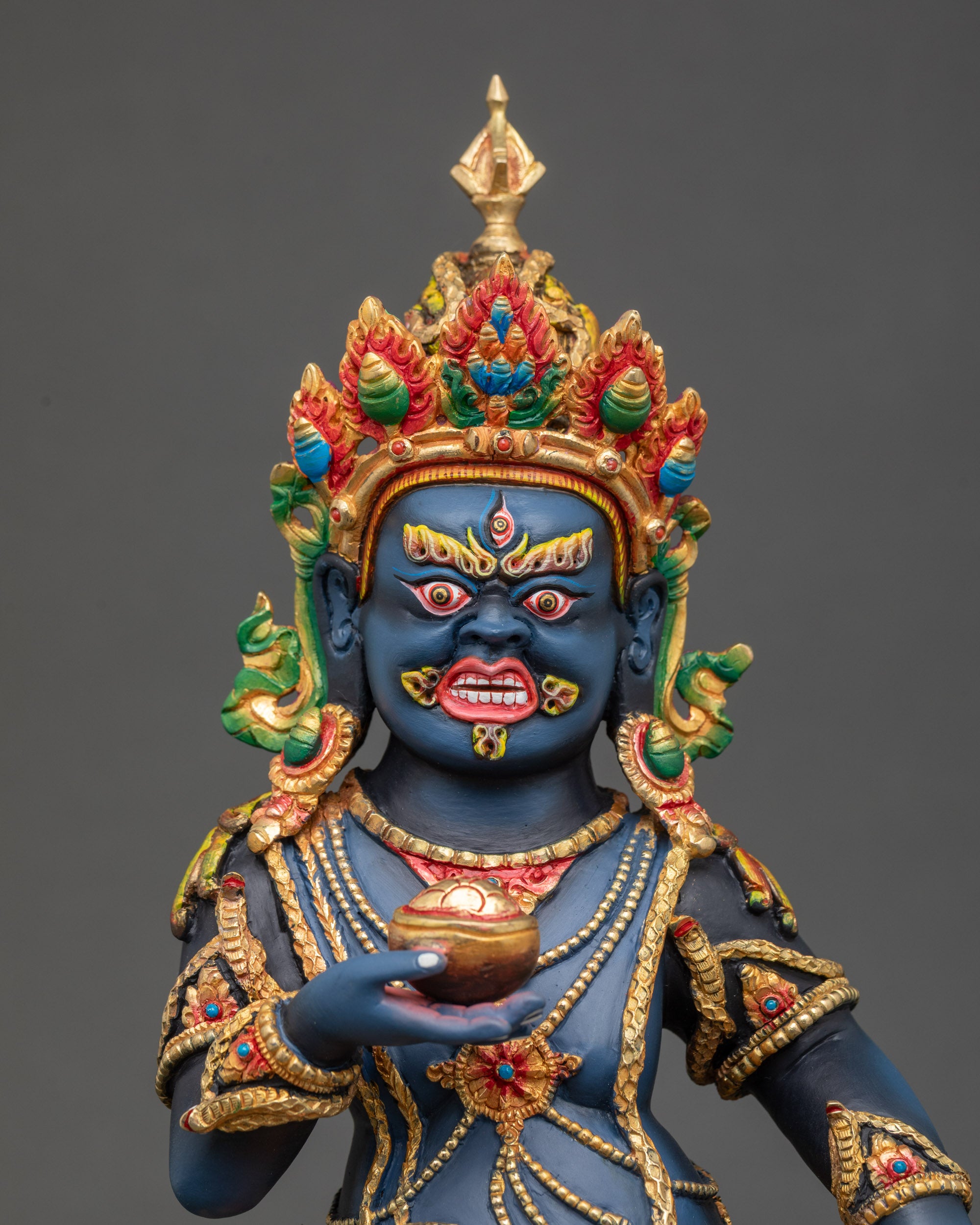 Regular close up of Black Dzambhala Statue showing jewel-spitting mongoose and kapala