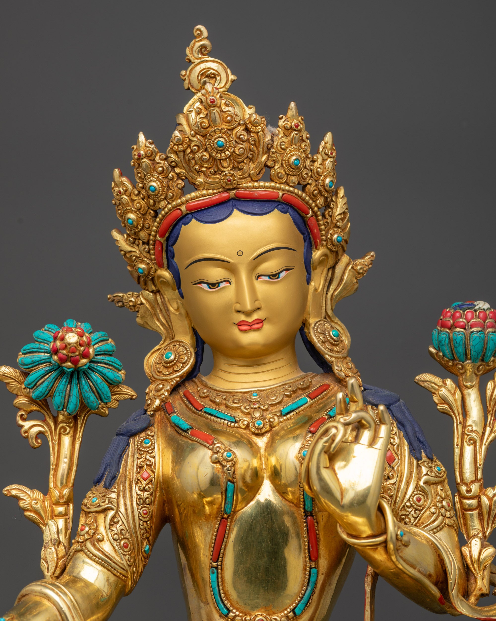 Regular close up of Green Tara statue highlighting floating robe and intricate lotus seat patterns