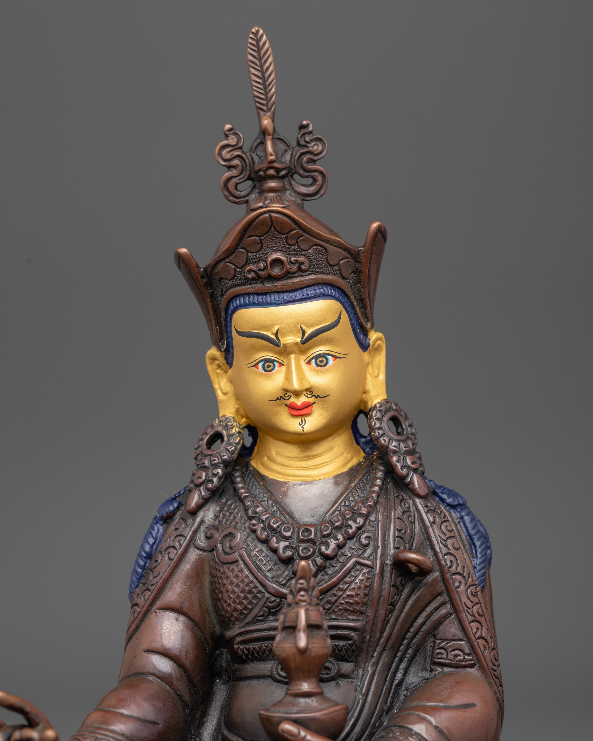 Regular close up of Guru Padmasambhava statue showing robes and flowing scarf