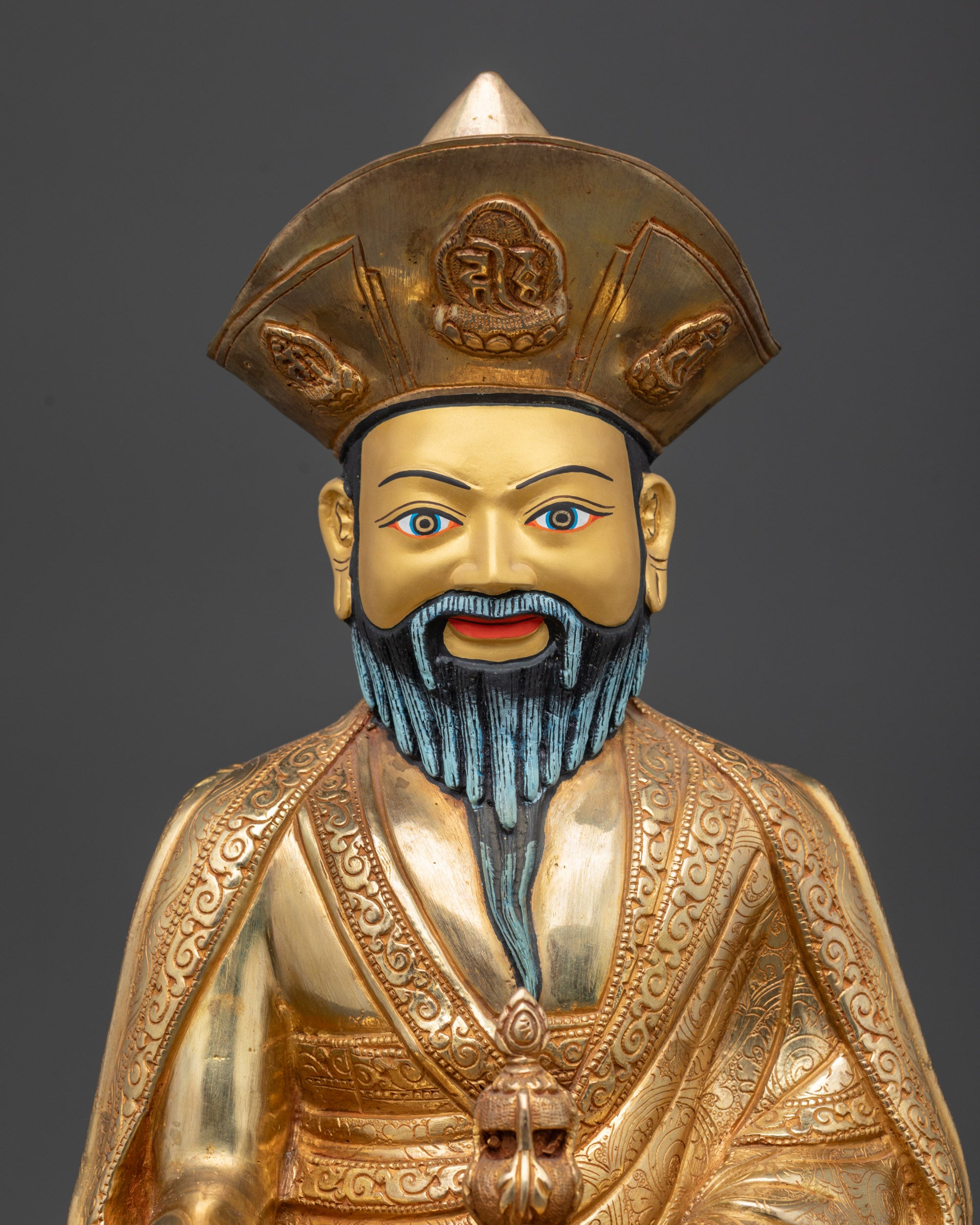 Regular close up of Guru Shapdum statue showing serene gaze and traditional lama hat
