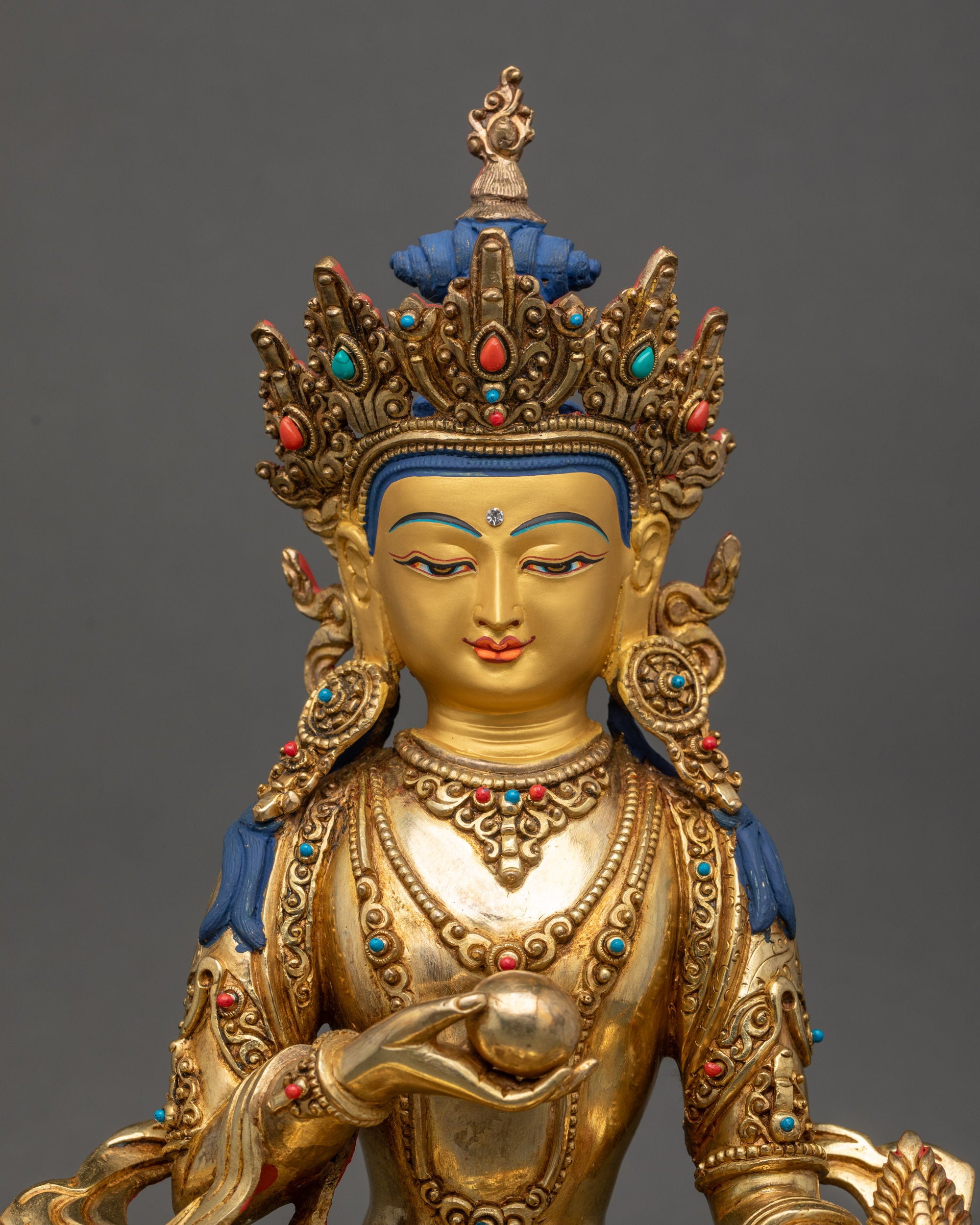 Regular close up of Ksitigarbha statue showing crown robe and semi-precious stones details