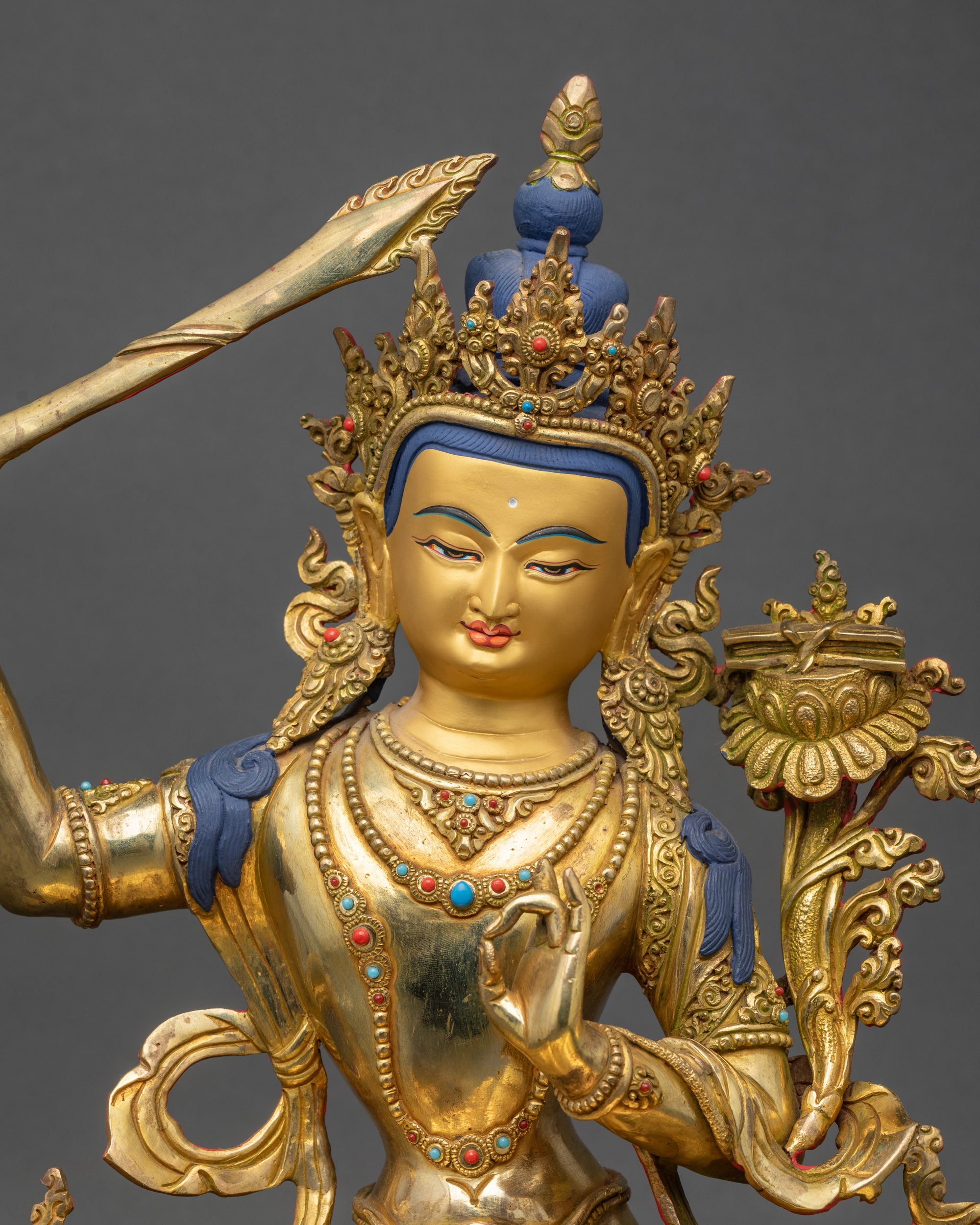 Regular close up of Manjushri Bodhisattva statue showing intricate swirling robes
