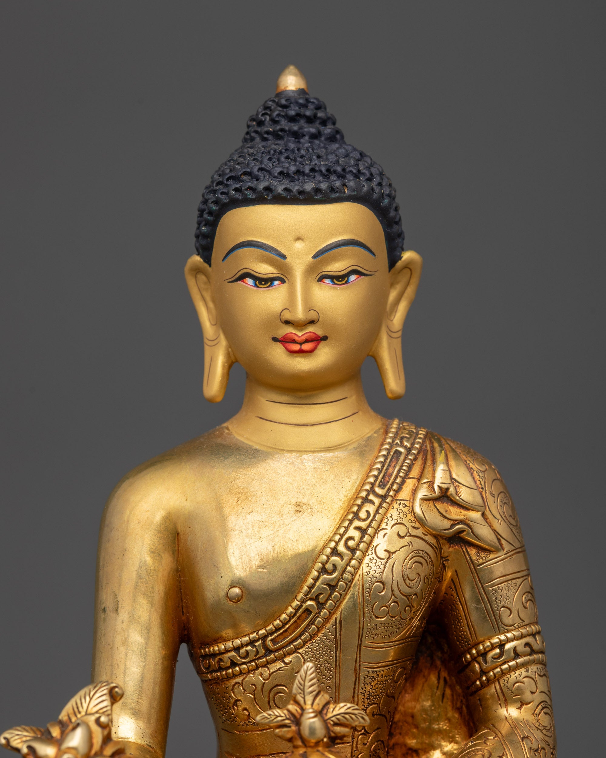 Regular close up of Medicine Buddha statue showing semi-precious stones on robe
