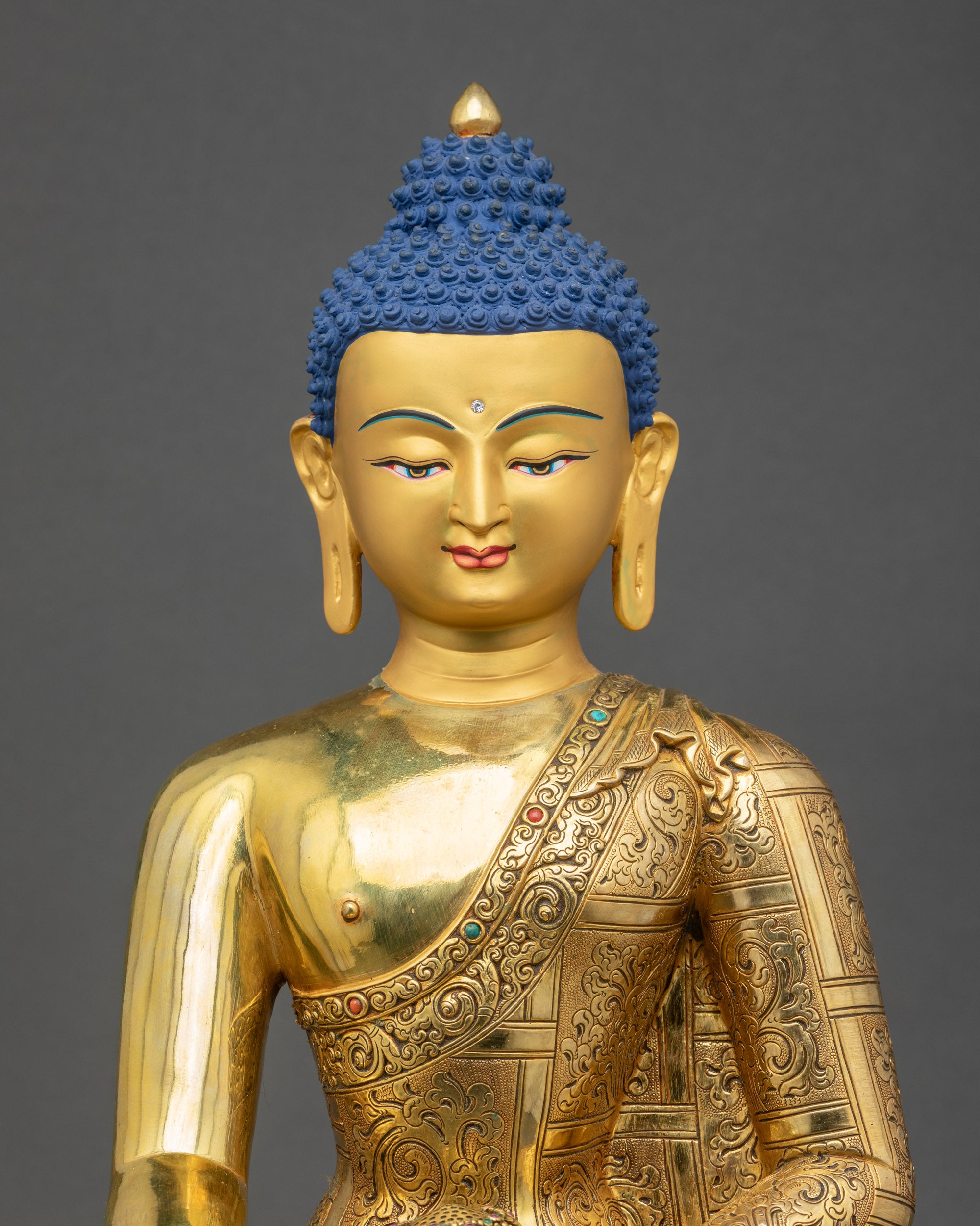 Regular close up of Shakyamuni Buddha Statue showing intricate robes and patra bowl