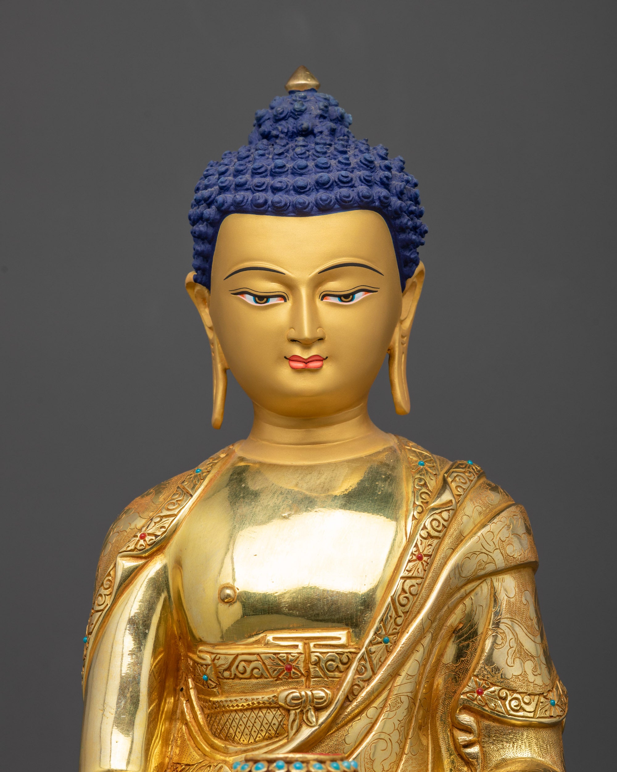 Regular close up of Shakyamuni Buddha statue showing intricate robe patterns
