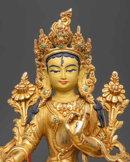 Regular close up of White Tara statue showing serene gold-gilded face and crown
